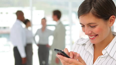 una mujer de negocios escribiendo en su teléfono.