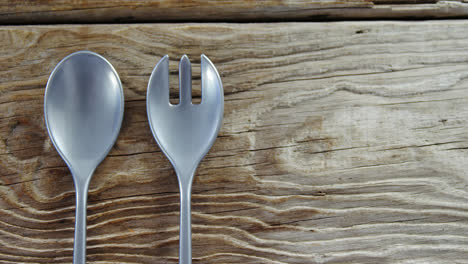 cuchara y tenedor en una mesa de madera