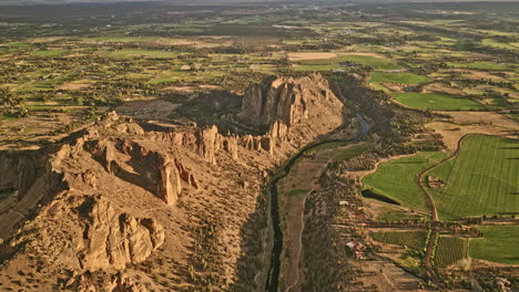 Terrebonne-Oregon-Aerial-v55-flyover-Smith-Rock-State-Park-along-Crooked-river,-capturing-spectacular-towering-rock-spires-surrounded-by-farmlands-at-sunset---Shot-with-Mavic-3-Cine---August-2022