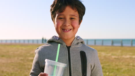 Boy,-face-and-drinking-by-the-ocean-on-a-leisure