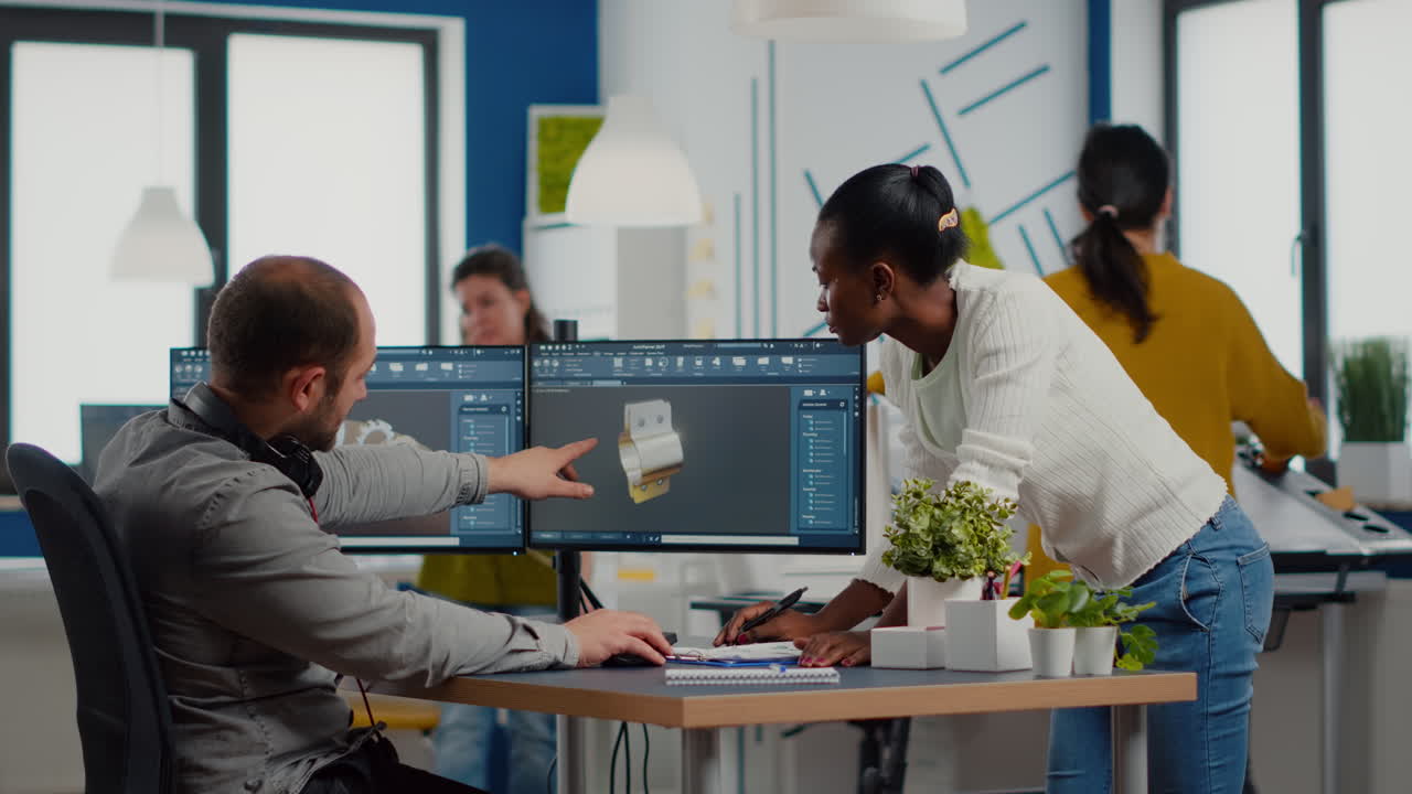 Diverse team of engineers working on computer at mechanical piece design