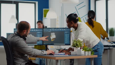 diverse team of engineers working on computer at mechanical piece design