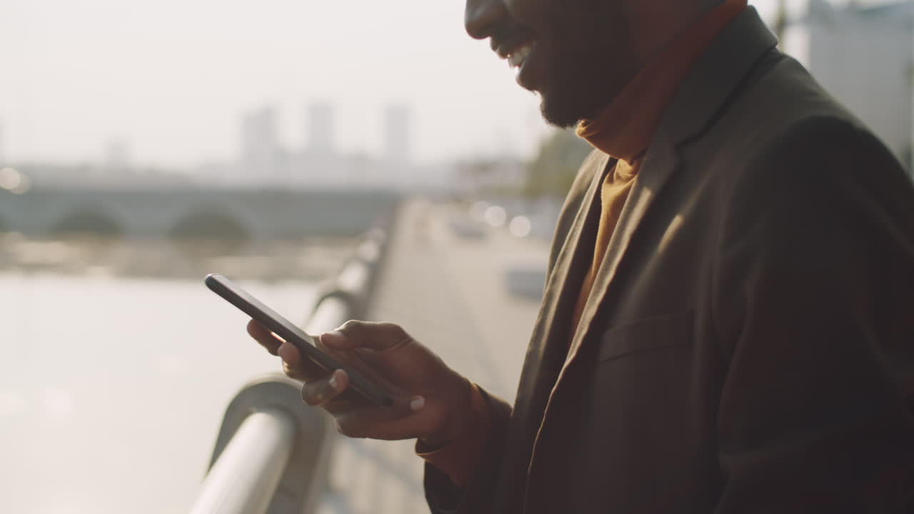 African American Businessman Typing on Smartphone Outdoors