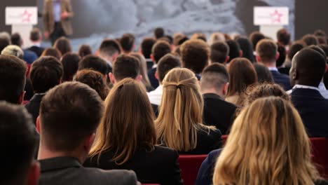 multitud de personas, hombres y mujeres, que asisten a la conferencia en el gran salón