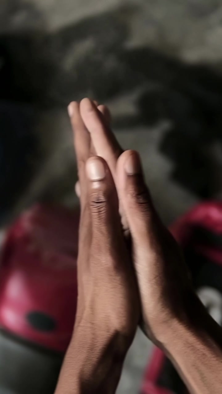 Uomo che si sfrega i palmi preparandosi per la boxe, linee animate che mostrano l'allineamento di guanti, dita e polso.