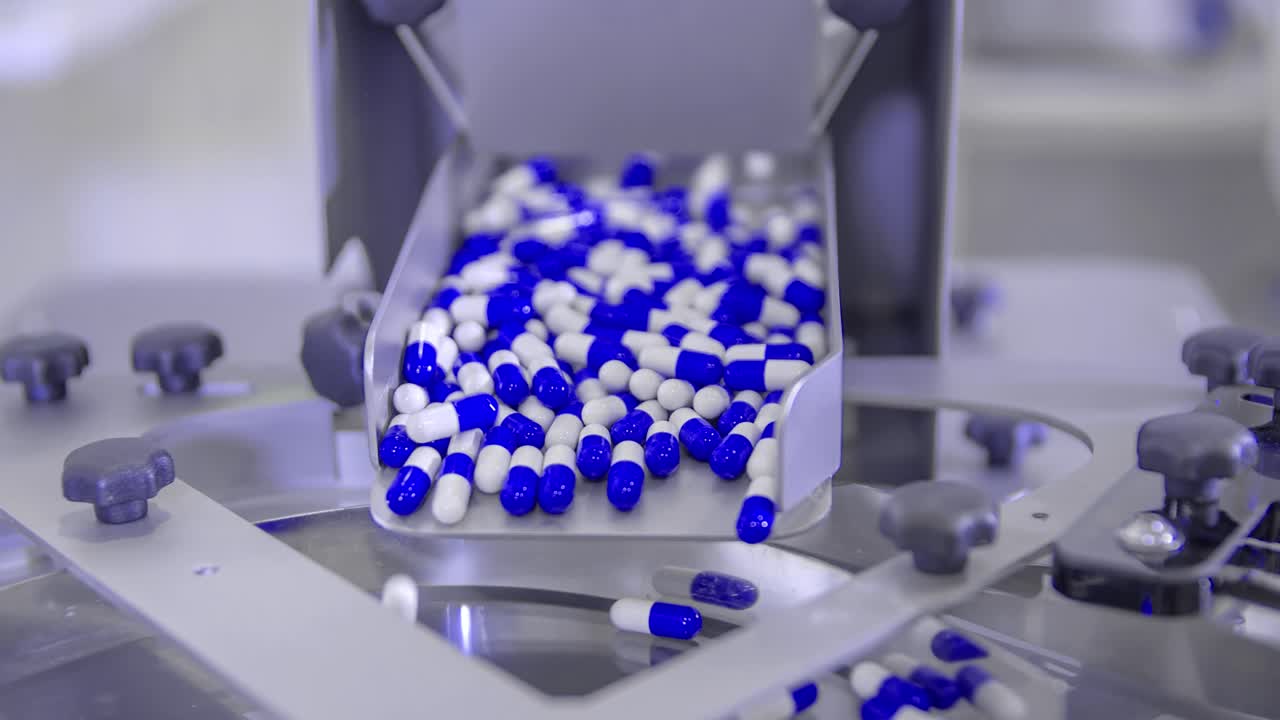 Blue and white pills fall into dispenser machine. Coronavirus cure medicine. Covid-19 pandemic