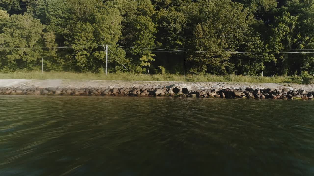 Revealing Aerial Shot of a Drain Pipes and Horizon of River Water