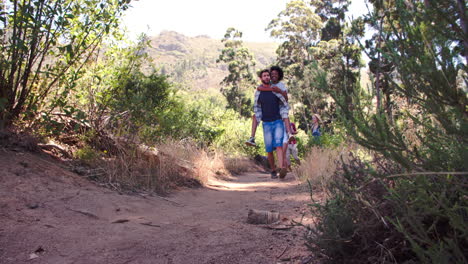 Cinco-Amigos-Caminando-Juntos-Por-Un-Sendero-Forestal,-Vista-De-ángulo-Bajo