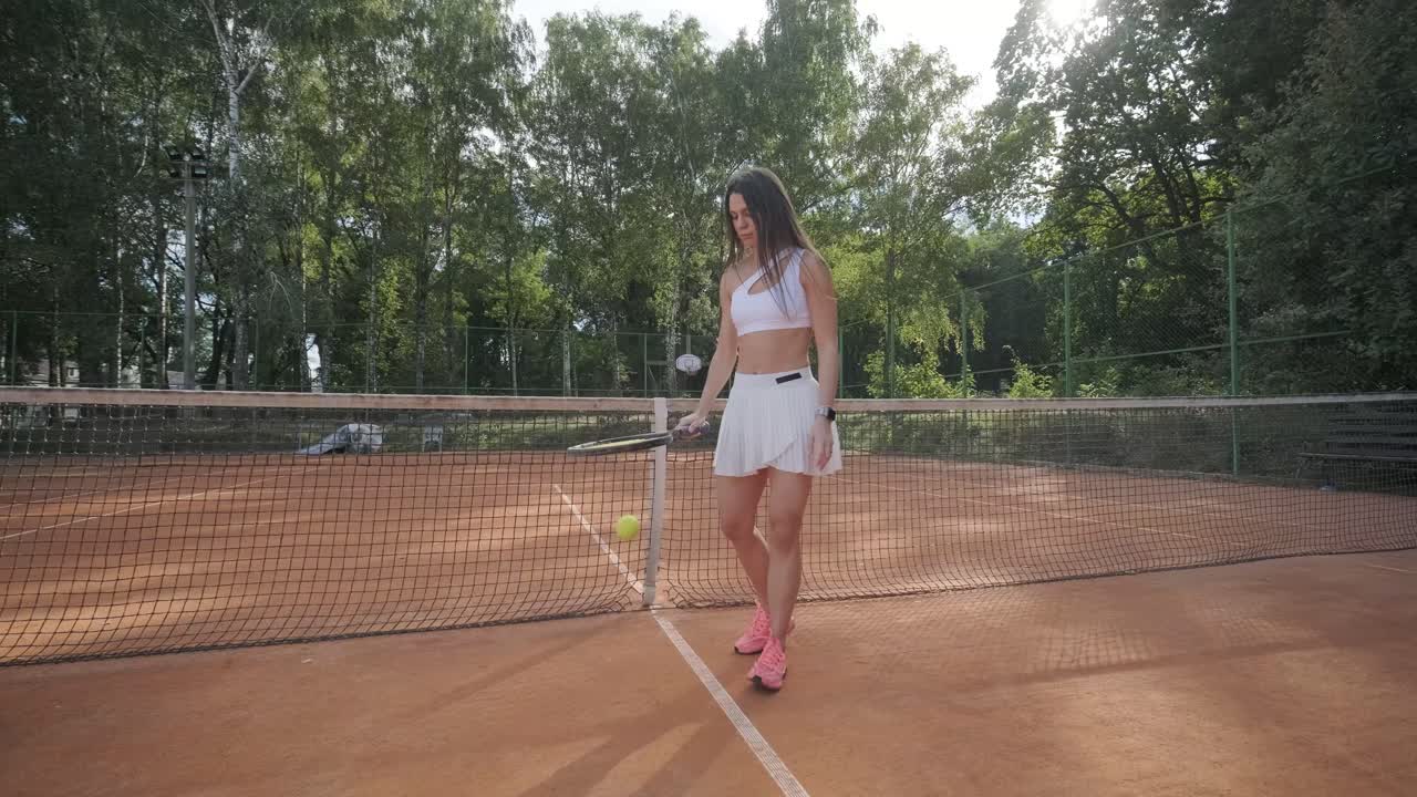 아름다운 테니스 소녀가 야외 코트에서 을 연습하고 있습니다.