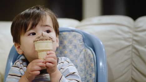 A-young-boy-of-two-years-old-eats-chocolate-ice-cream.-Sits-in-a-high-chair