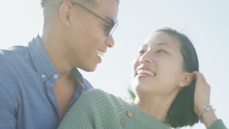 Happy-biracial-couple-embracing-on-promenade,-in-slow-motion