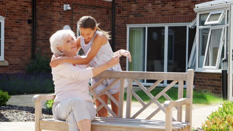 Granddaughter-Greeting-Grandmother-On-Visit-To-Retirement-Home