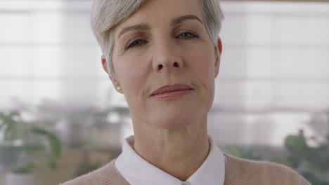 close-up-portrait-of-confident-mature-caucasian-woman-looking-serious-pensive-at-camera-in-plants-background