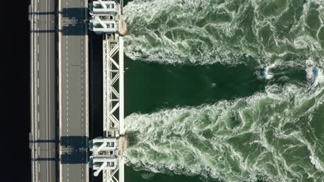 Verlassene-Nordseestraße-Und-Fließendes-Wasser-Aus-Der-Oosterschelde-Sturmflutwehr-Im-Niederländischen-Dorf-Kamperland