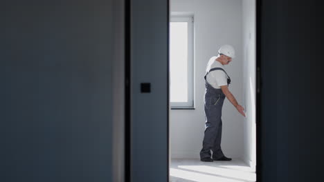 An-electrician-in-a-helmet-installs-and-checks-LED-strips-for-illumination-in-the-apartment.-Turn-on-and-check-the-light-and-decorative-lights.-Look-at-the-operation-of-the-backlight