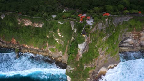 Aerial-View-Of-Uluwatu-Temple-Perched-On-The-Sheer-Sea-Cliffs-In-South-Kuta,-Badung,-Bali-Indonesia