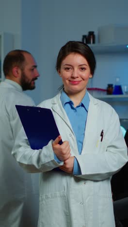 scientist posing in a lab with a clipboard