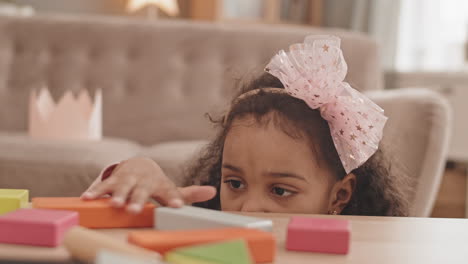 girl playing with colorful toy bricks