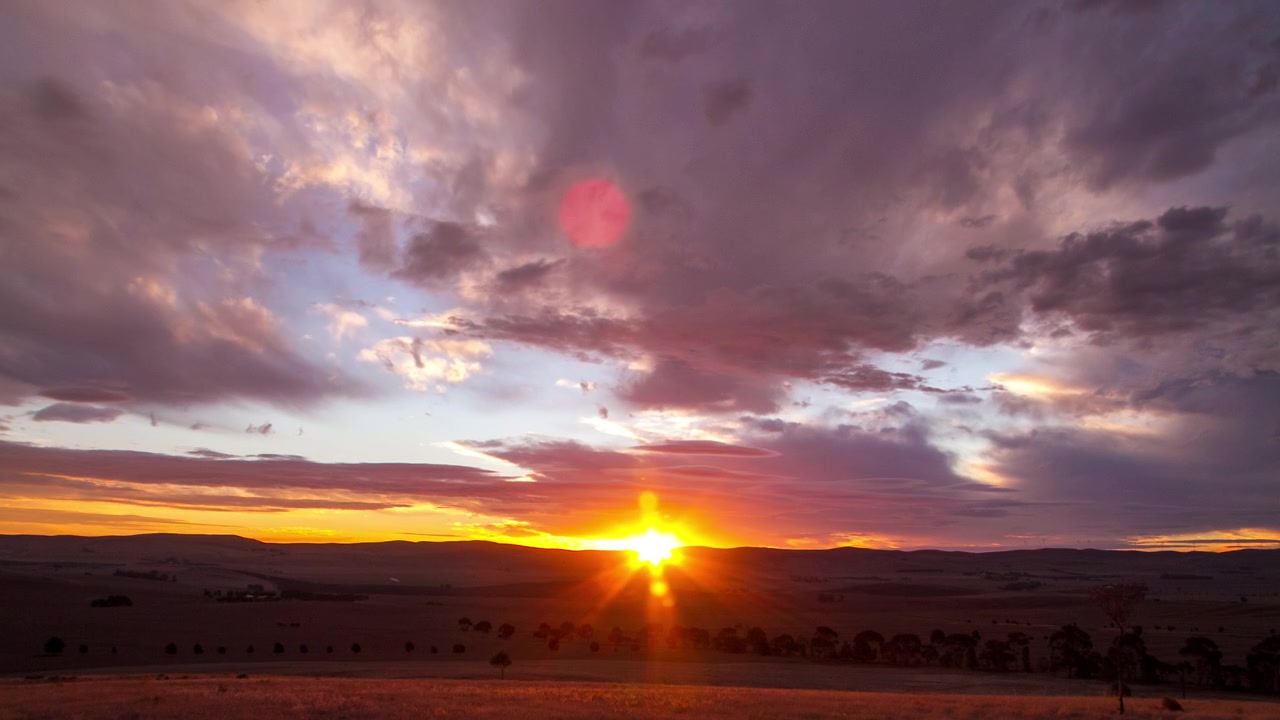 Time-lapse del tramonto con strati di nuvole che si muovono su un distretto agricolo collinare nella regione Mid North dell'Australia Meridionale