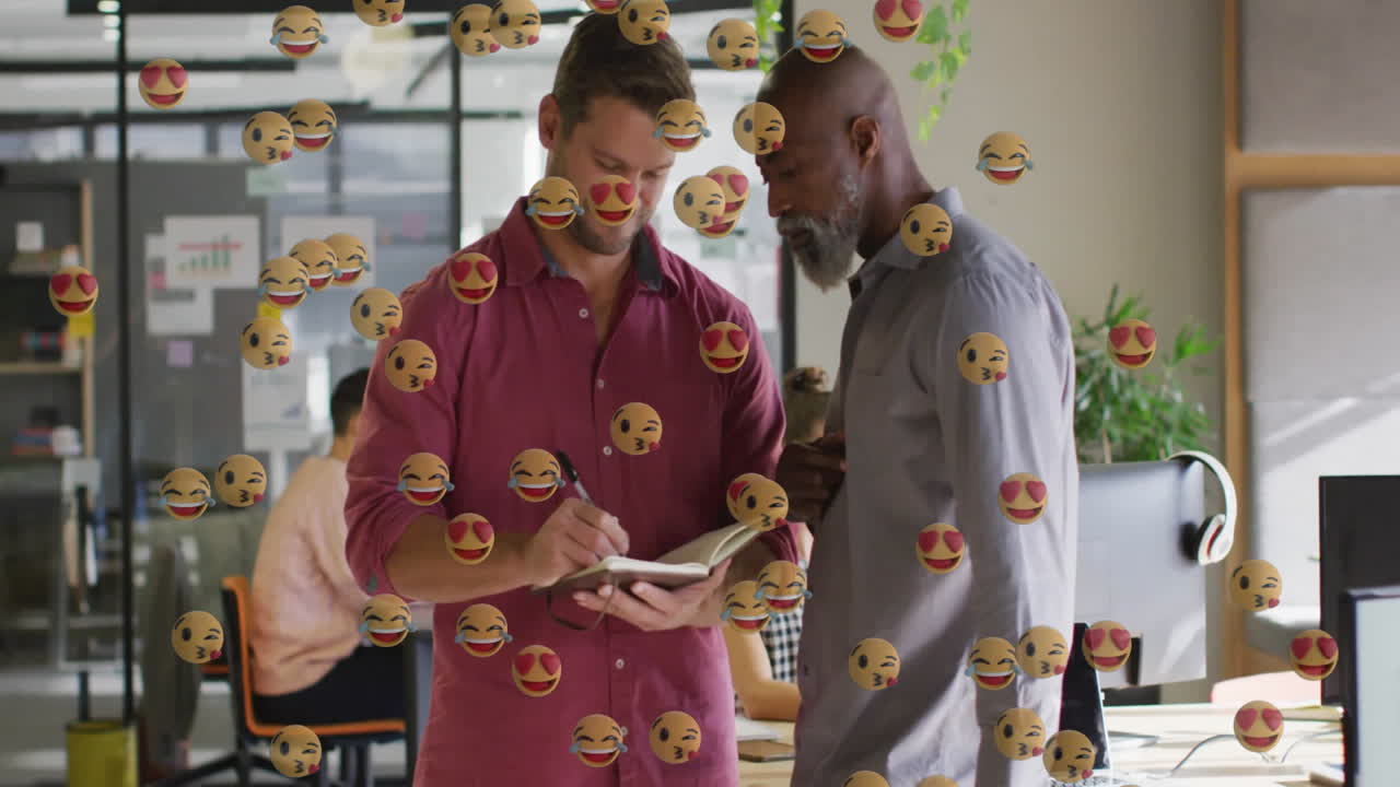 Two male colleagues writing notes in business office, displaying animated charts and sticky notes