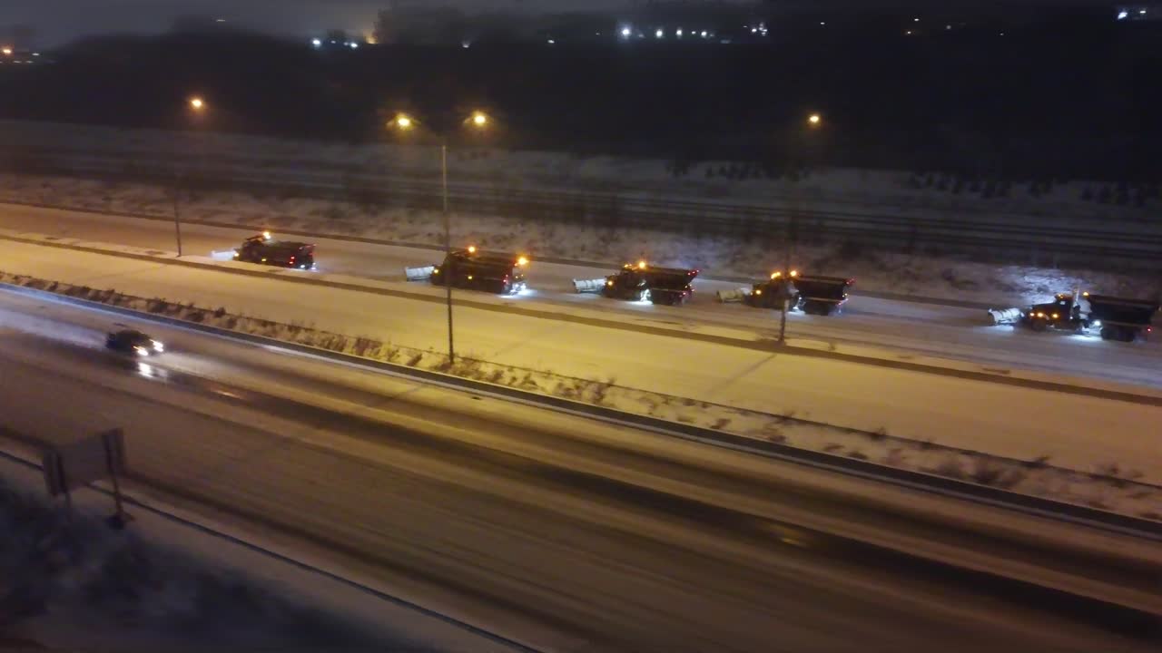 Rows Of Snow Ploughs Driving Across Highway At Night In Montreal