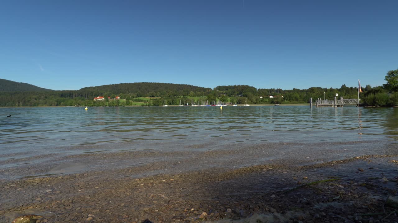 маленькие волны популярной туристической точки баварии тегернзее, красивый вид с низкой точки зрения на большое озеро в южной баварии