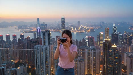 joyful cityscape moments: a young woman captures the vibrant skyline of a metropolis while enjoying the stunning sunset view from a high rooftop