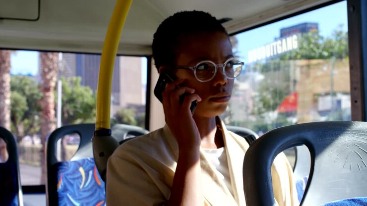 Female commuter talking on mobile phone while travelling in bus 4k