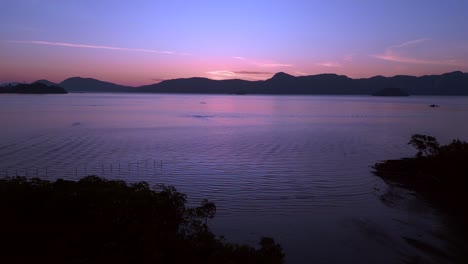 Colorful-hues-over-the-ocean,-islands-before-sunrise