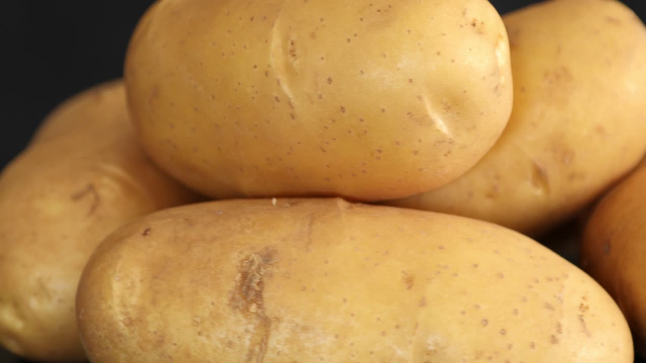 patatas crudas que giran y giran aisladas sobre un fondo negro 6