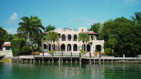 waterfront mansion on star island in miami day time blue skies green palm trees