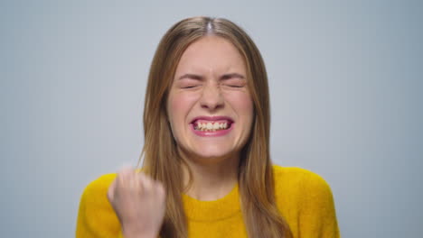 Portrait-of-happy-attractive-woman-showing-yes-gesture-on-grey-background.