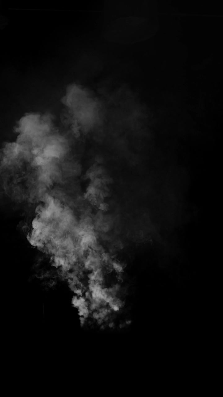 Siyah arka plan üzerinde soldan sağa sürüklenen izole edilmiş beyaz duman tutamı. Sihir, buhar veya atmosferik detaylar için ince bir görsel efekt öğesi, dikey format.