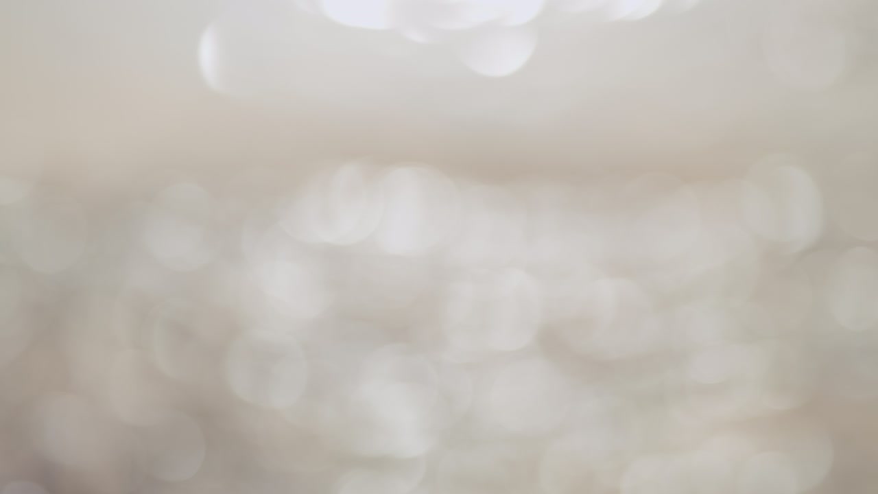 Beautiful sparkling shiny texture of blurry gold river water with sun reflected on surface. Out of focus.