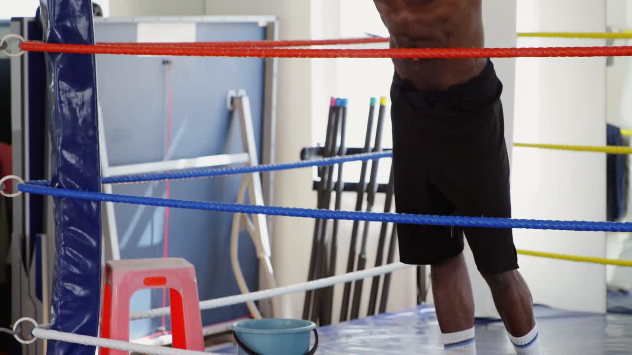 Pugile uomo che si rilassa sul ring di pugilato 4k