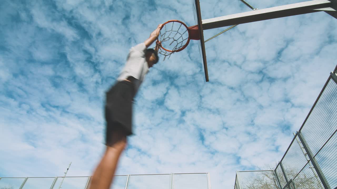 Black guy throwing basketball ball into ring