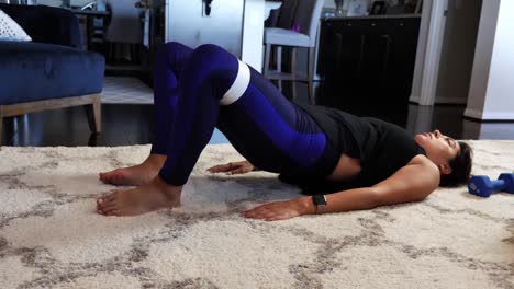 female on floor in house, working out, fitness and exercise with stretching band on legs, hispanic