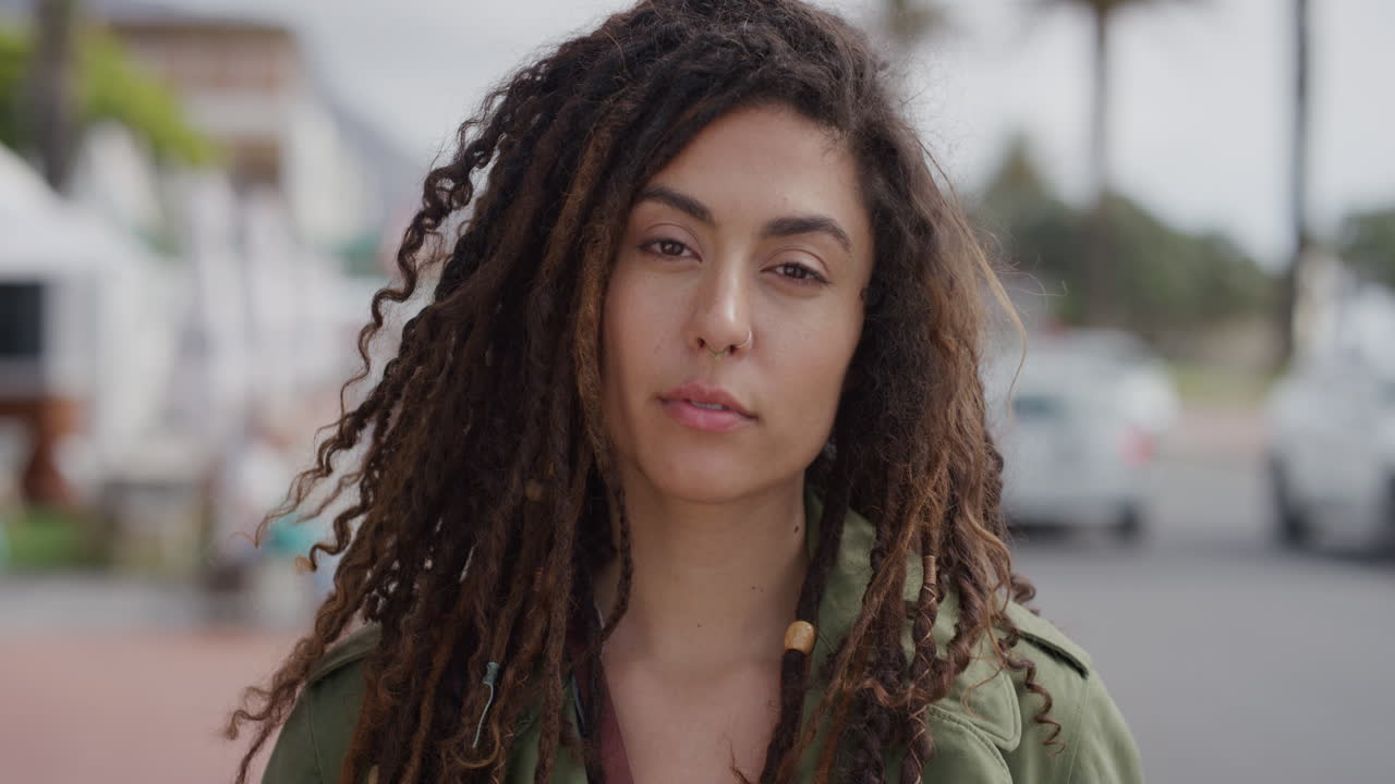 retrato de una hermosa mujer joven que mira con confianza a la cámara disfrutando de un estilo de vida de vacaciones independientes en un soleado día urbano frente a la playa