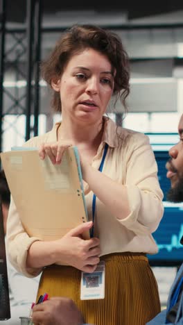vertical video multiethnic work team consulting each other in completing monthly reports