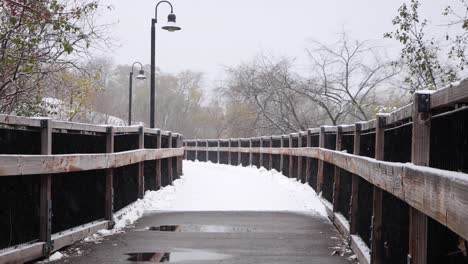 viejo puente de madera cubierto de nieve durante las nevadas frescas