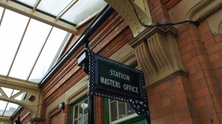 Primo piano dell'insegna dell'ufficio del capostazione in una vecchia stazione ferroviaria britannica
