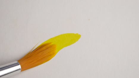 yellow paint stroke with paintbrush