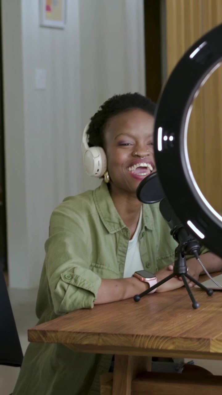 Vertical video: Starting recording woman speaking into mic in studio, green top headset, copy space