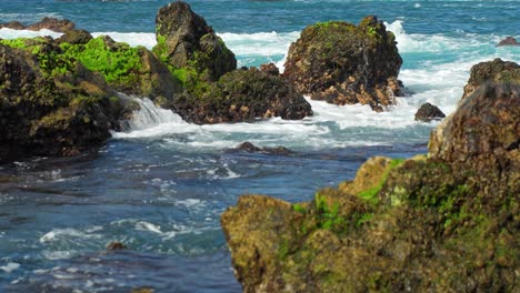 las olas salpicando las rocas cubiertas de musgo en el mar mediterráneo