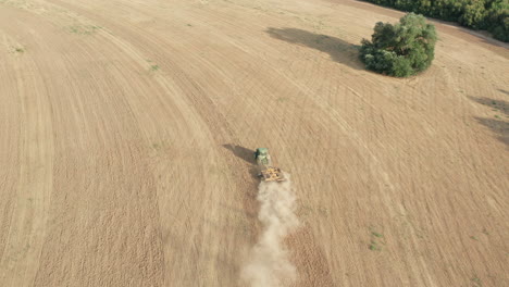 agricultural tractor plowing farm land - descending aerial tilt-up reveal