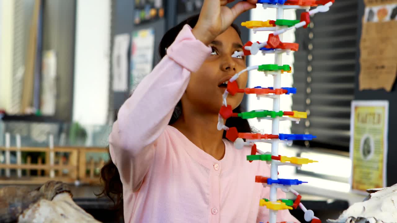 un escolar experimentando con un modelo de molécula en el laboratorio 4k
