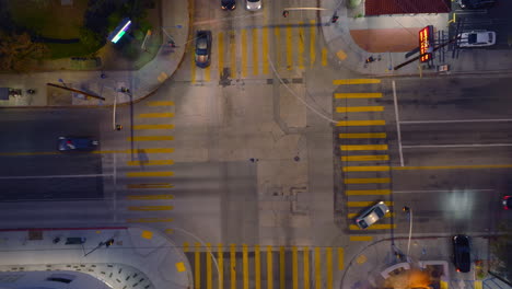 toma aérea de drones de autos que se mueven a través de una intersección concurrida al atardecer, tráfico crepuscular