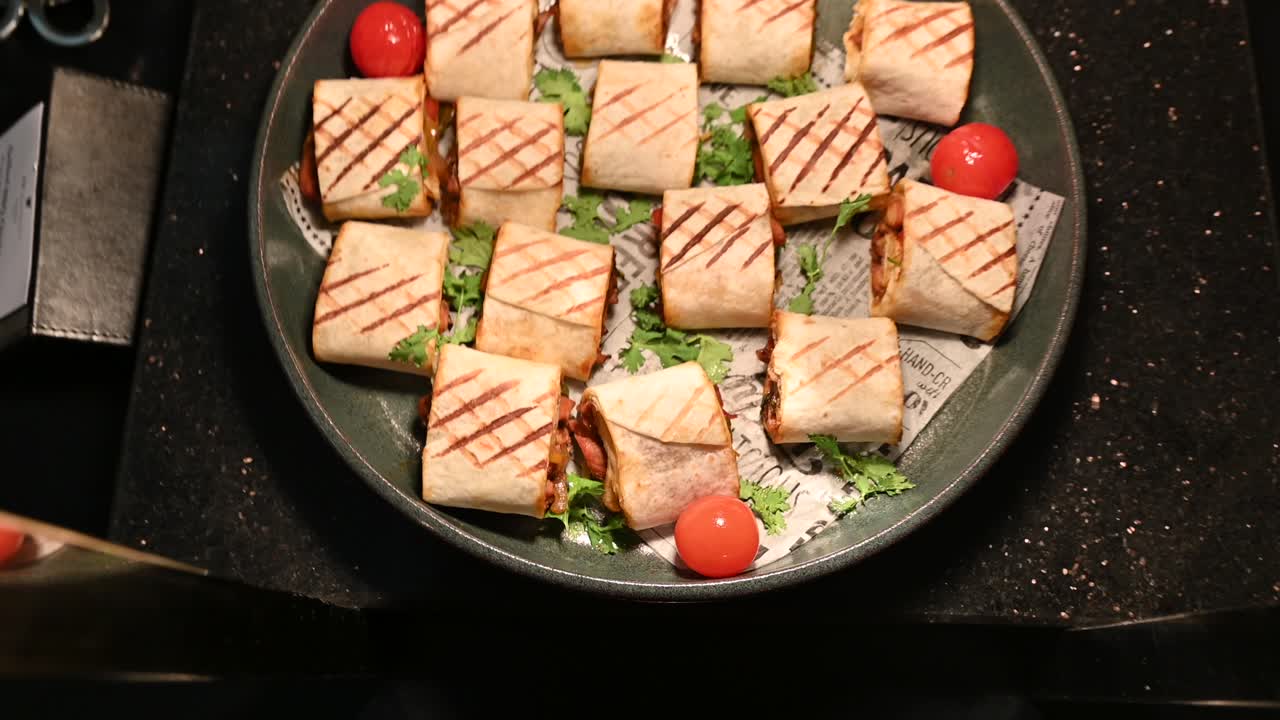 trozos de pollo y carne de shawarma envueltos en pan de tortilla a la parrilla