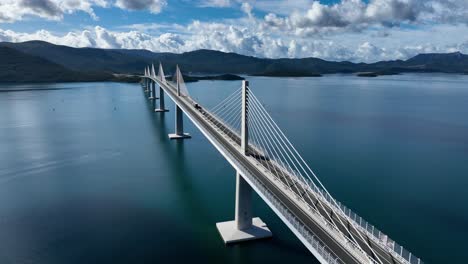 aerial fly vehicle traffic at peljesac bridge, cable-stayed connection above the water of dubrovnik neretva county, croatia