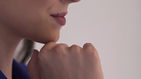 happy woman with lipstick touches chin by hand on set